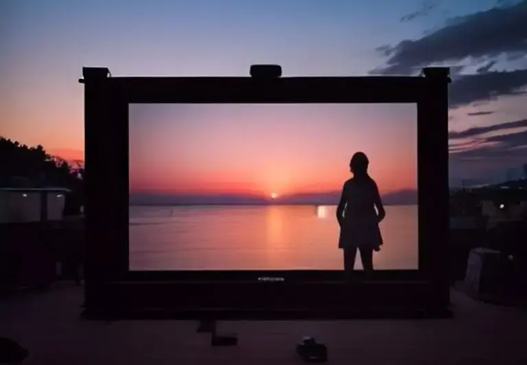 Pantalla de cine junto al mar al atardecer (ilustración IA)