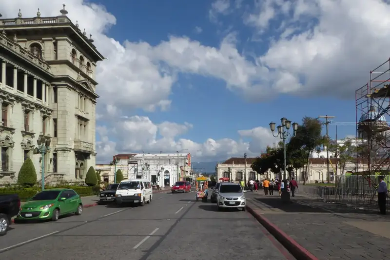 Calle junto a la Plaza de la Constitución de Ciudad de Guatemala, con el Palacio Nacional a la izquierda