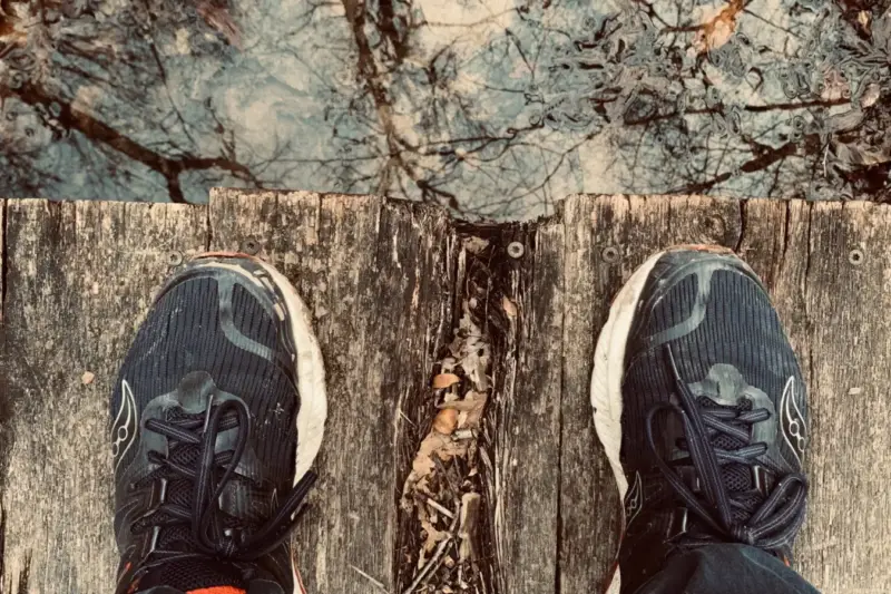 Zapatillas de deporte sobre un camino en un parque, simbolizando la carrera solidaria por la investigación.