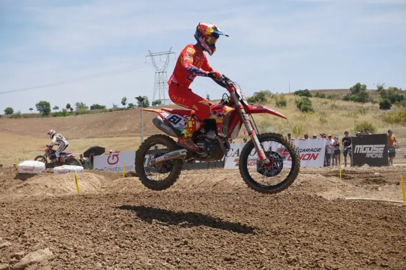 Jorge Prado salta con su moto de motocross roja sobre la tierra de un circuito durante el GP de España de 2022