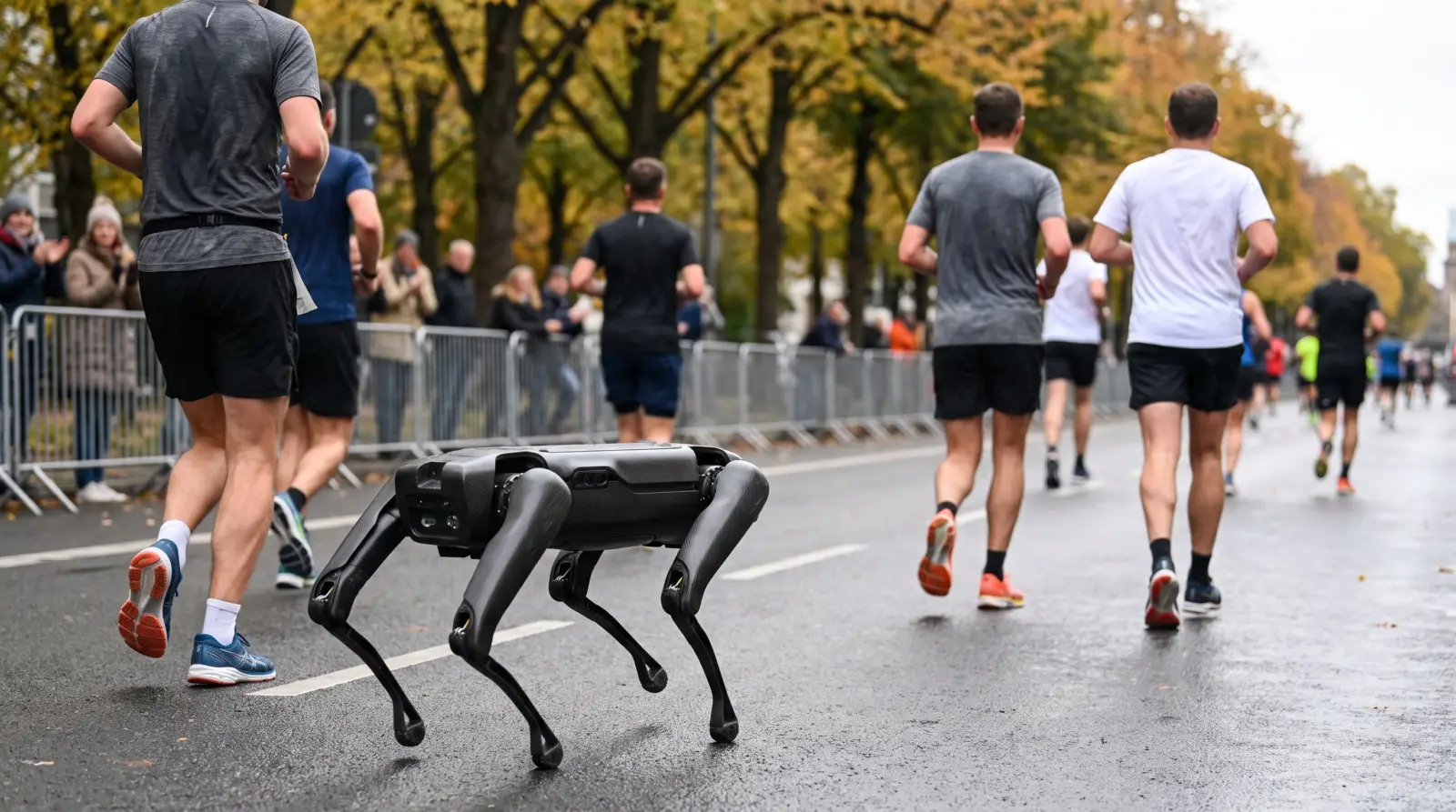 Robot cuadrúpedo corre por una carretera junto a corredores anónimos durante una maratón urbana