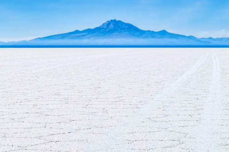 El volcán Tunupa se alza sobre la llanura blanca del salar de Uyuni, en Bolivia
