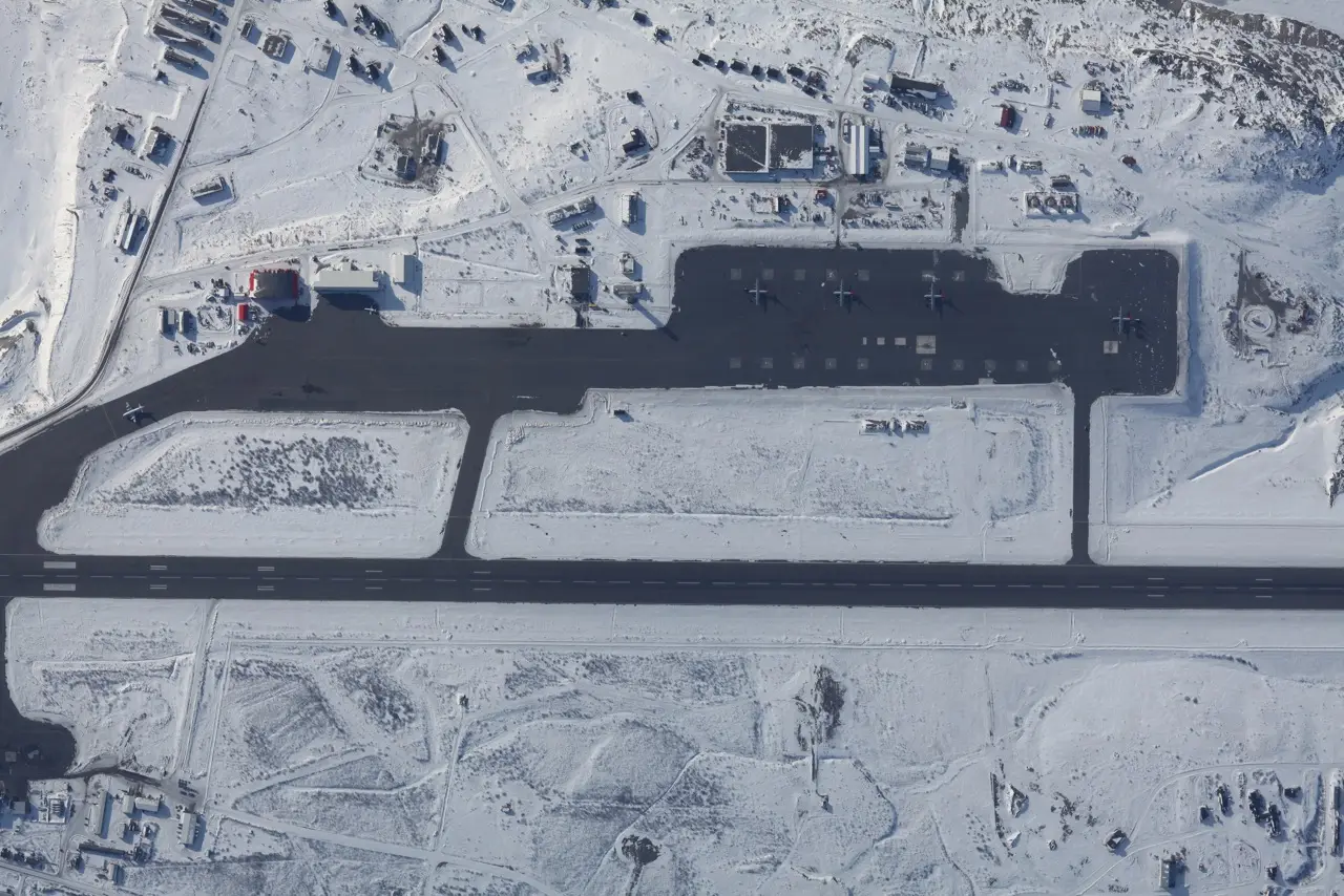 Pista y terminal de un aeropuerto en una zona ártica, con aeronave estacionada y un horizonte de hielo al fondo.