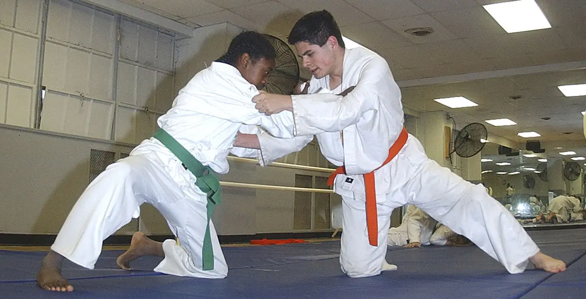 Detalle de una judoca compitiendo sobre un tatami en un campeonato profesional.