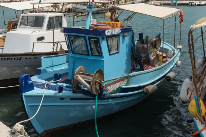 Barcos de pesca amarrados en un muelle de piedra de un puerto asturiano al amanecer