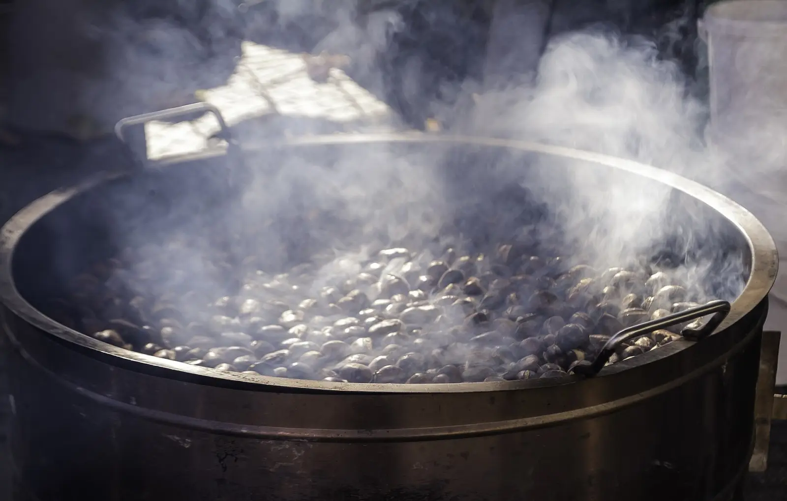 Castañas asadas en una plaza de pueblo al atardecer, con vecinos reunidos en otoño