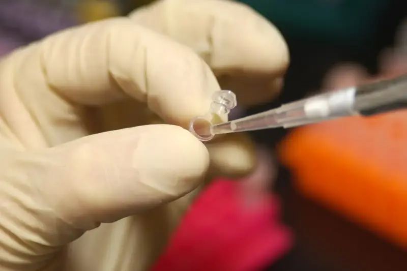 Investigadora trabajando con muestras en un laboratorio de investigación biomédica.
