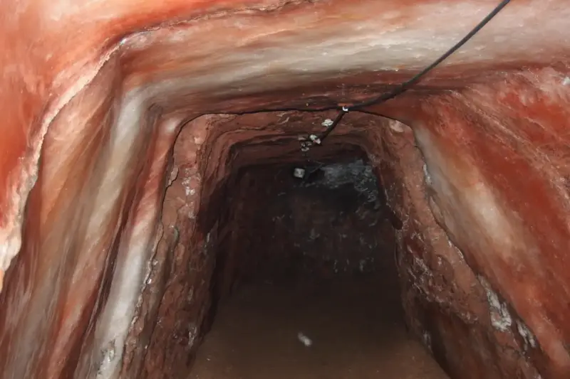 Interior de un antiguo túnel de sal con paredes de roca natural y texturas cristalinas en una mina de los Alpes.