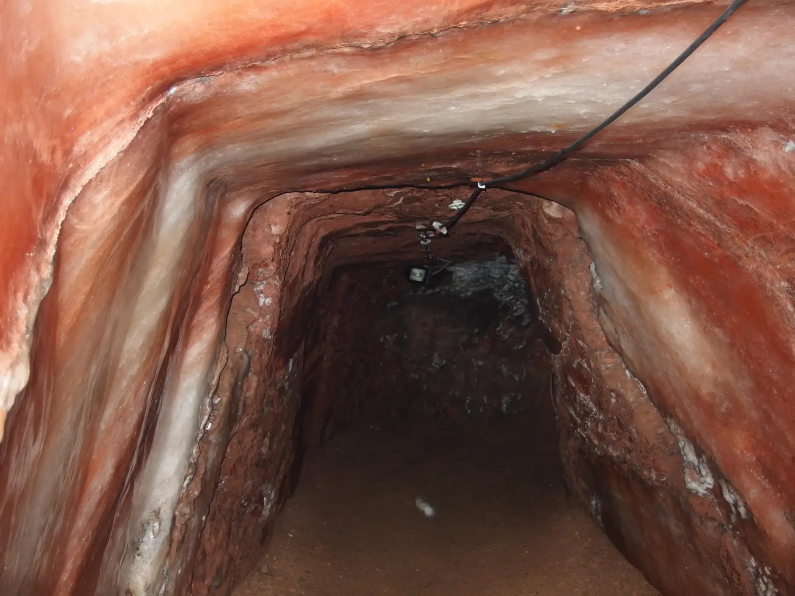 Interior de un antiguo túnel de sal con paredes de roca natural y texturas cristalinas en una mina de los Alpes.