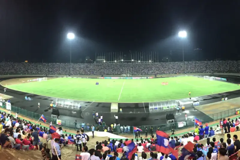 Jugador de fútbol durante un partido profesional en un estadio iluminado.