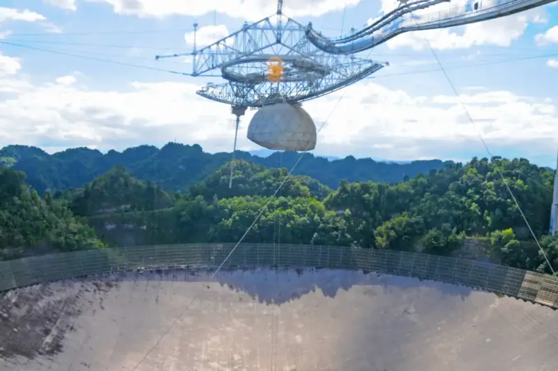 Radiotelescopio apuntando al cielo nocturno para la observación astronómica.