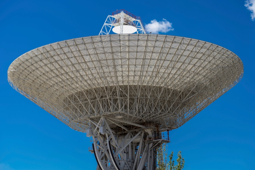 Pantallas de control en un observatorio astronómico mostrando ondas de radio y datos científicos.