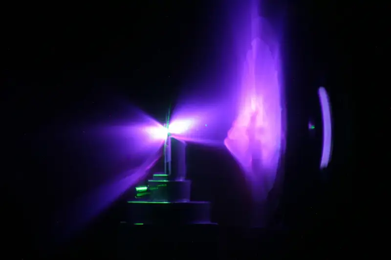 Equipo de laboratorio con un cristal de torio bajo luz láser en un entorno de investigación científica.