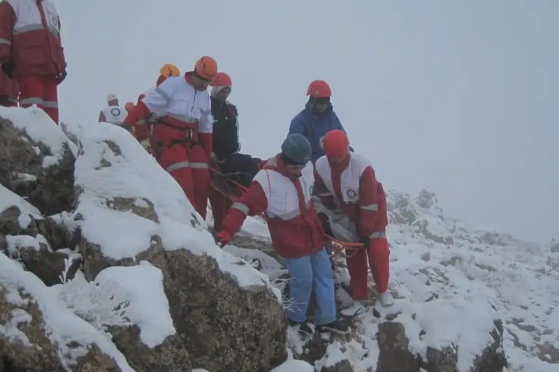 Hombre mayor sosteniendo un trofeo de madera en un salón con fotografías de montaña al fondo