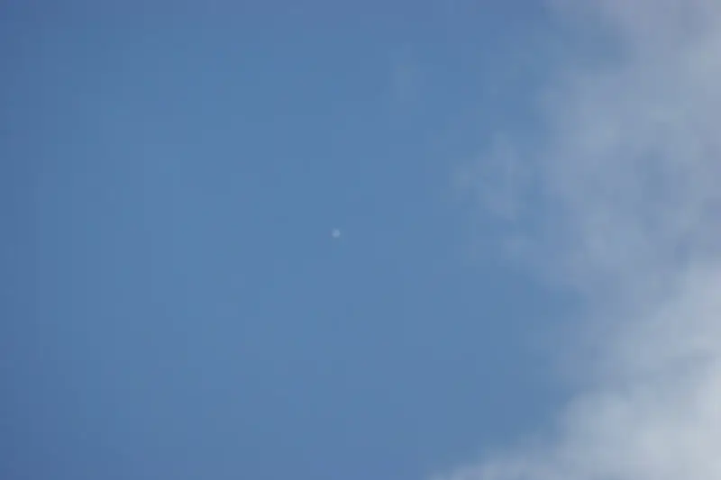 Pequeño escenario de juguete sujeto a un globo de gran altitud con el cielo y el horizonte de fondo