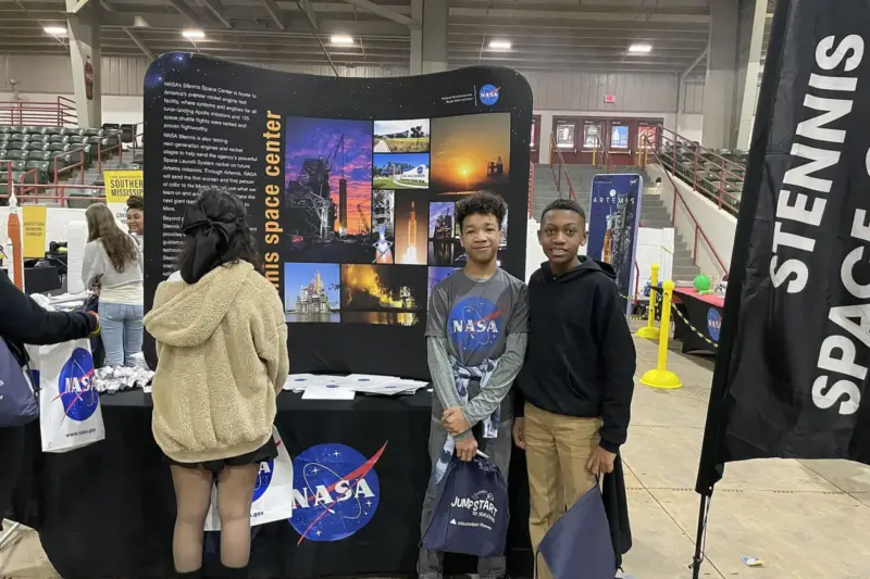 Estudiantes de secundaria siguiendo una proyección sobre astronomía en un aula universitaria con luz natural de tarde.