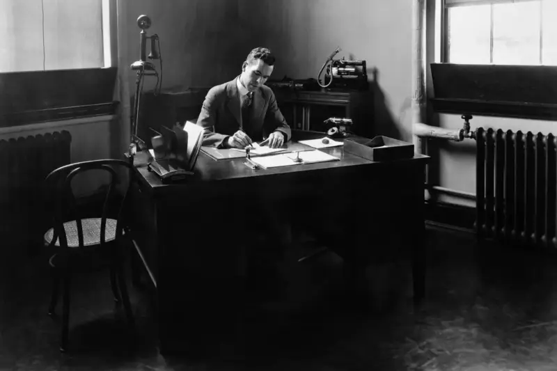 Escritorio de investigación con una pantalla que muestra una curva de brillo estelar, con la luz azulada del monitor y una…
