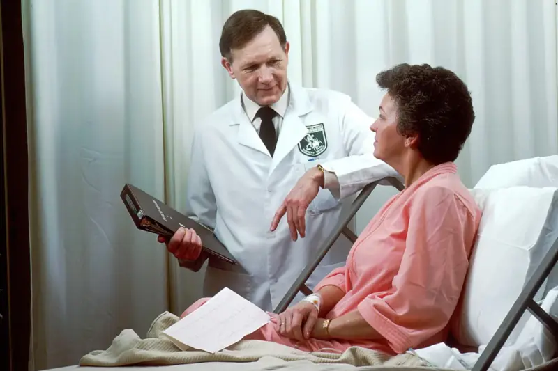 Médico revisando imágenes en un monitor durante una consulta oncológica en un hospital