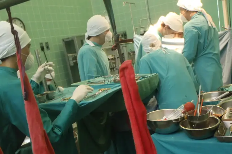 Quirófano con un equipo médico trabajando sobre la superficie de un corazón durante una intervención.
