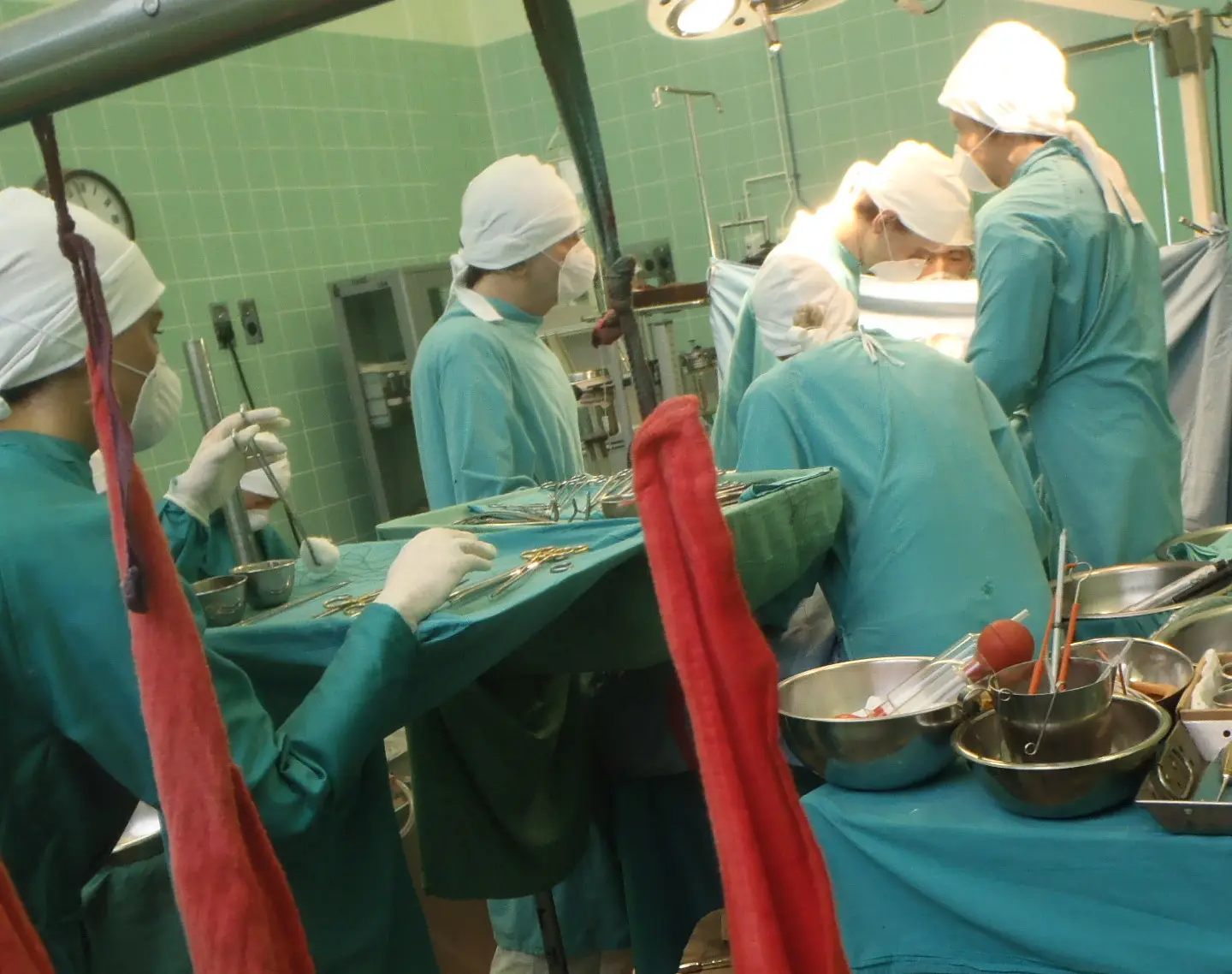 Quirófano con un equipo médico trabajando sobre la superficie de un corazón durante una intervención.