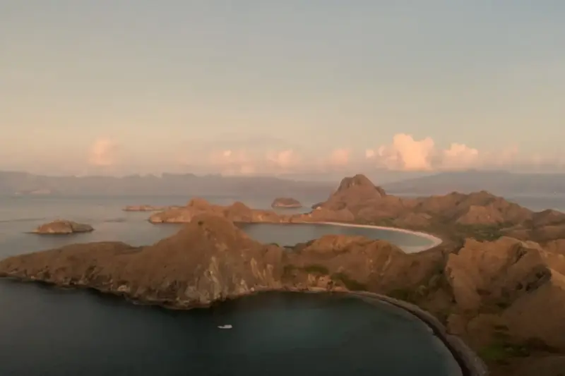 Acantilados y costa de una isla rocosa tras una tormenta, con el mar gris bajo un cielo nublado.