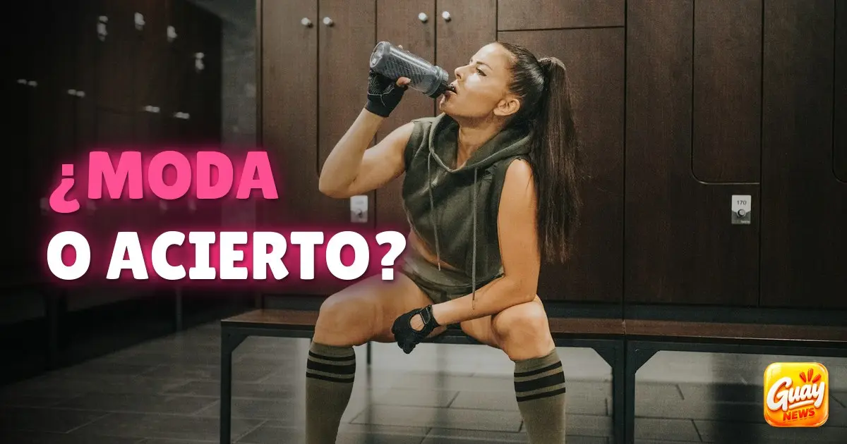 Mujer bebiendo de una botella reutilizable en el vestuario del gimnasio