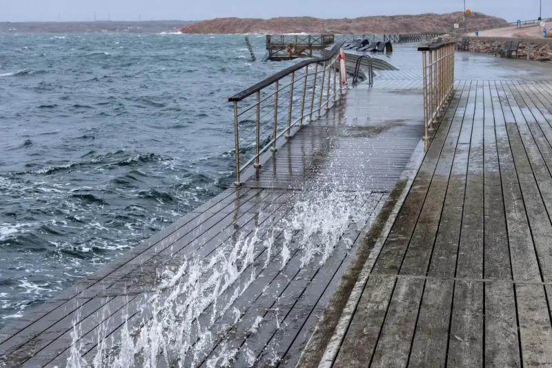 Olas rompiendo con fuerza contra un acantilado de la costa bajo un cielo gris de tormenta