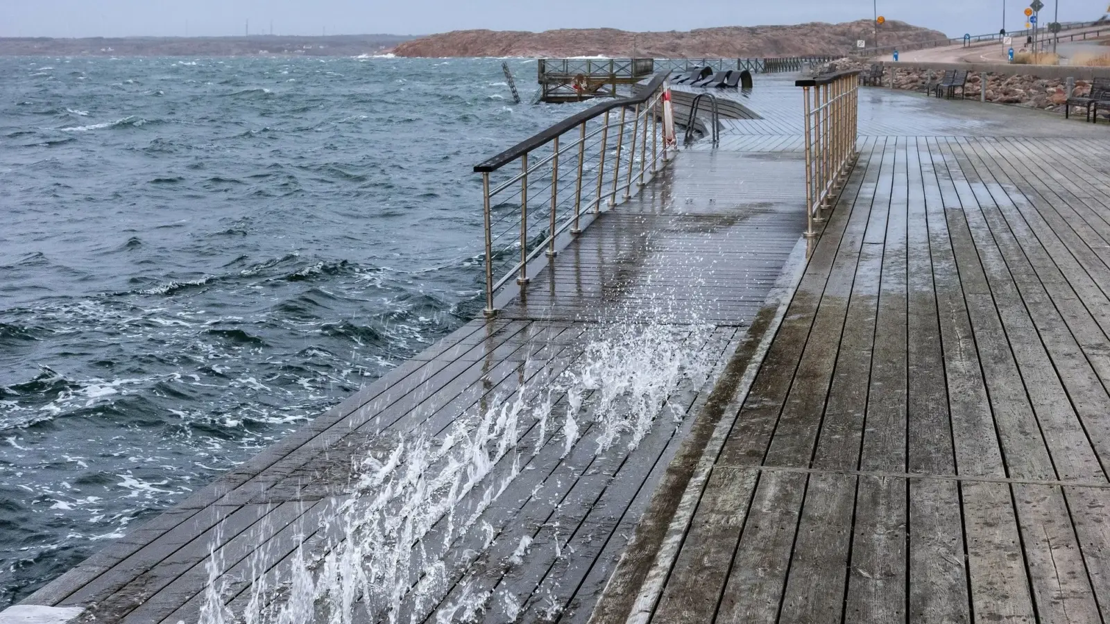 Olas rompiendo con fuerza contra un acantilado de la costa bajo un cielo gris de tormenta