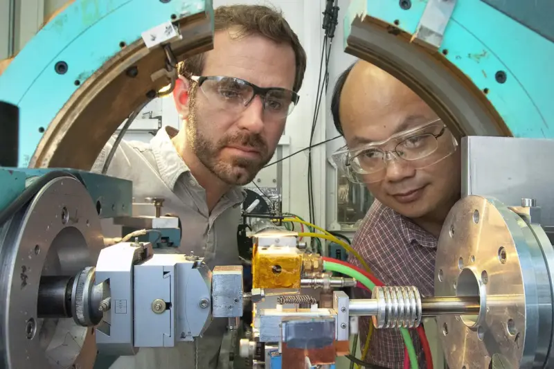 Técnico trabajando en un laboratorio con un prototipo conectado a un banco de baterías y un osciloscopio