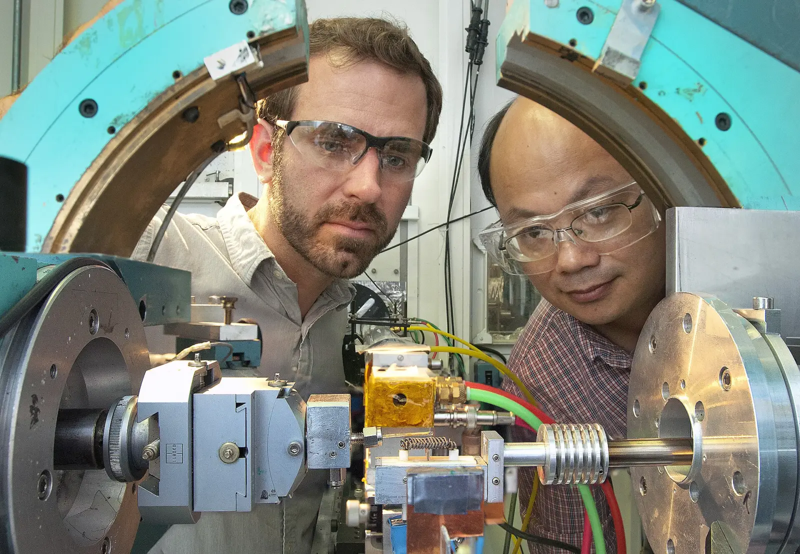 Técnico trabajando en un laboratorio con un prototipo conectado a un banco de baterías y un osciloscopio