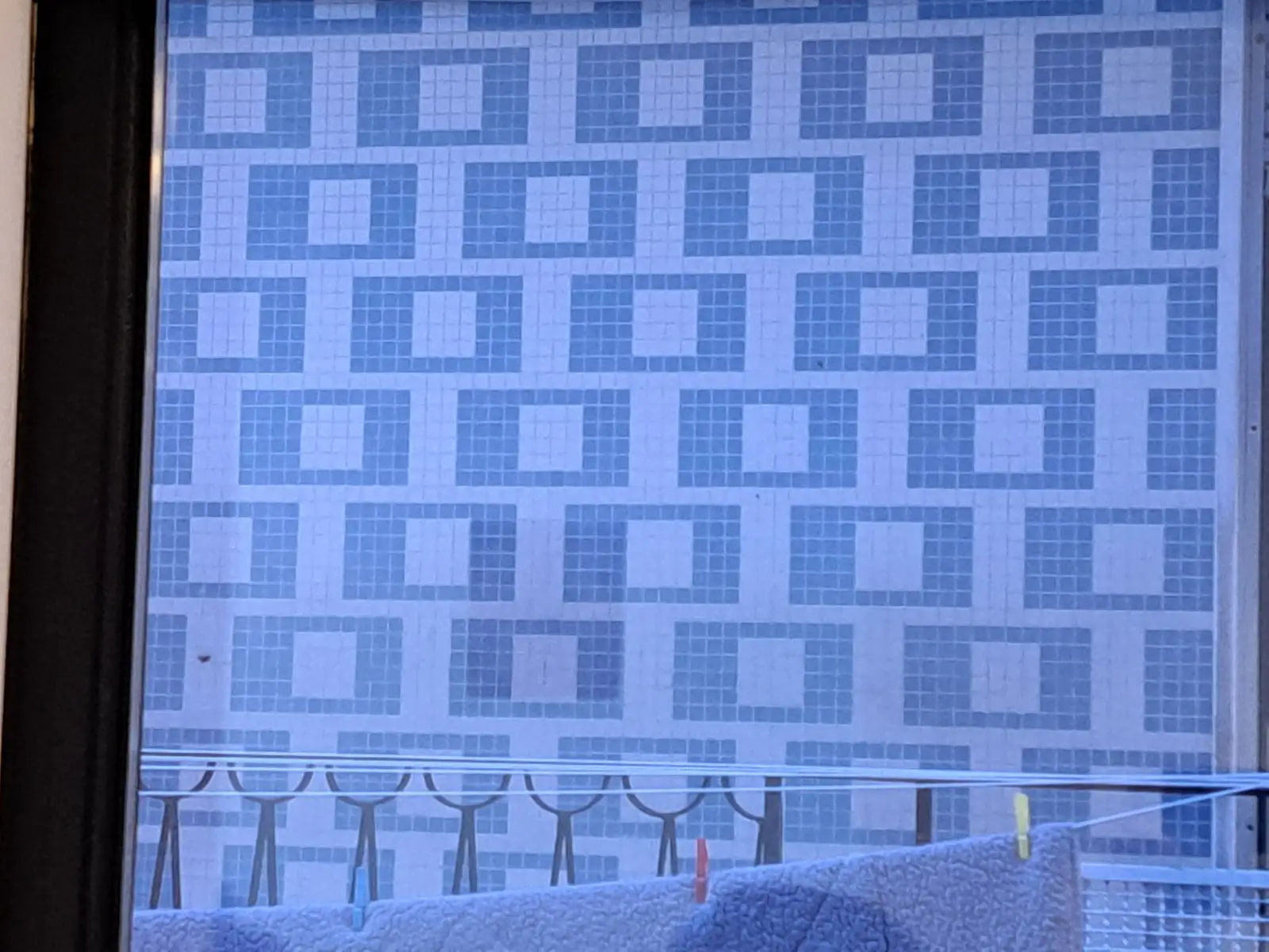 Estudiante limpiando con un pincel azulejos antiguos descubiertos bajo la cal en un muro de un convento.