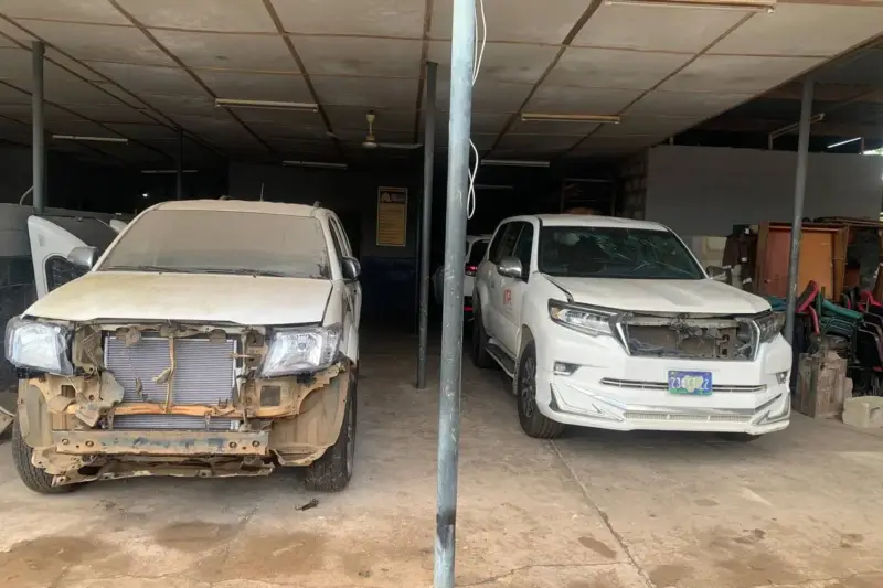 Estudiantes de carrocería junto a un coche Hyundai gris recién reparado en un taller
